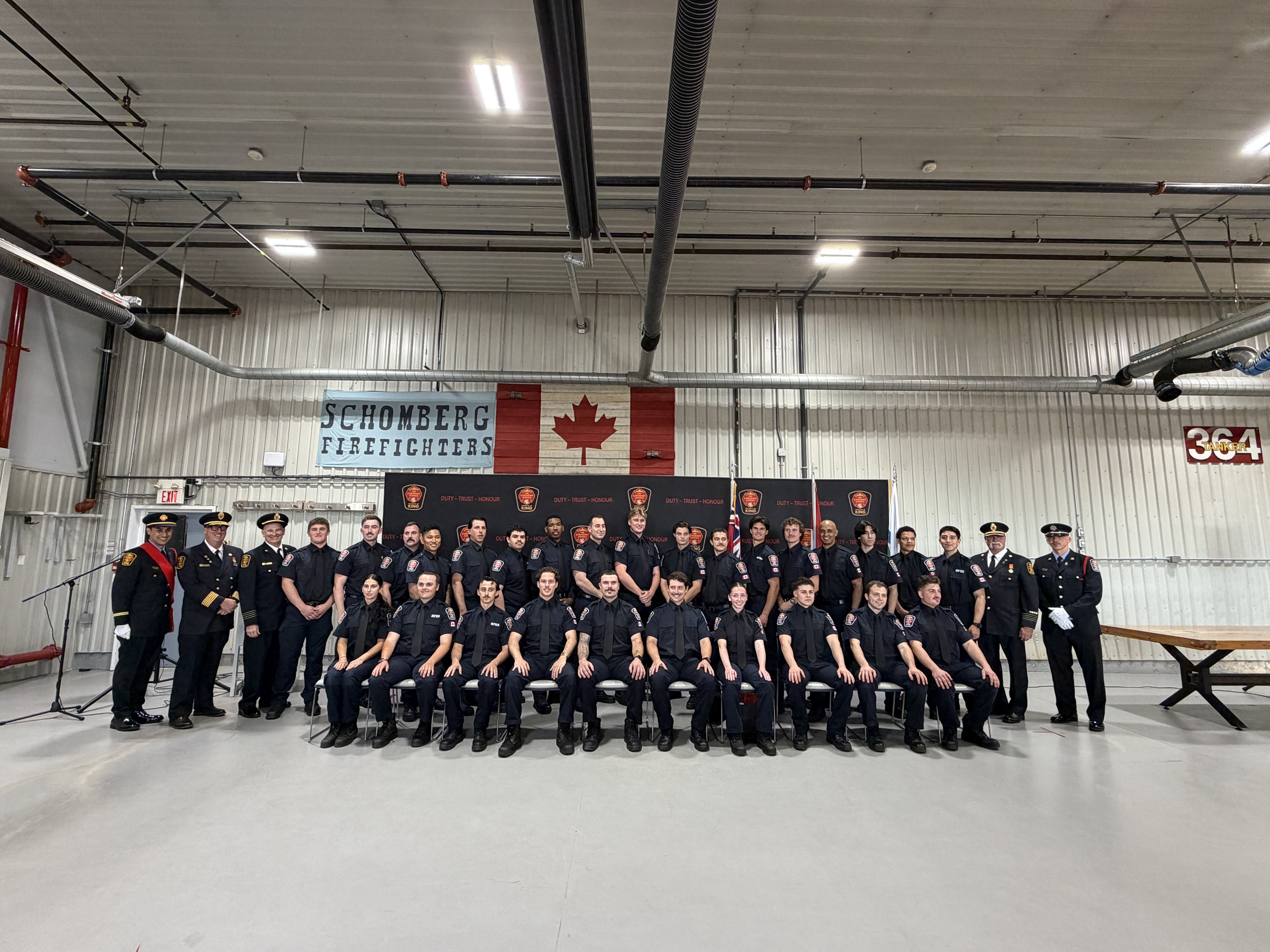 Firefighters and recruits gathered in two rows
