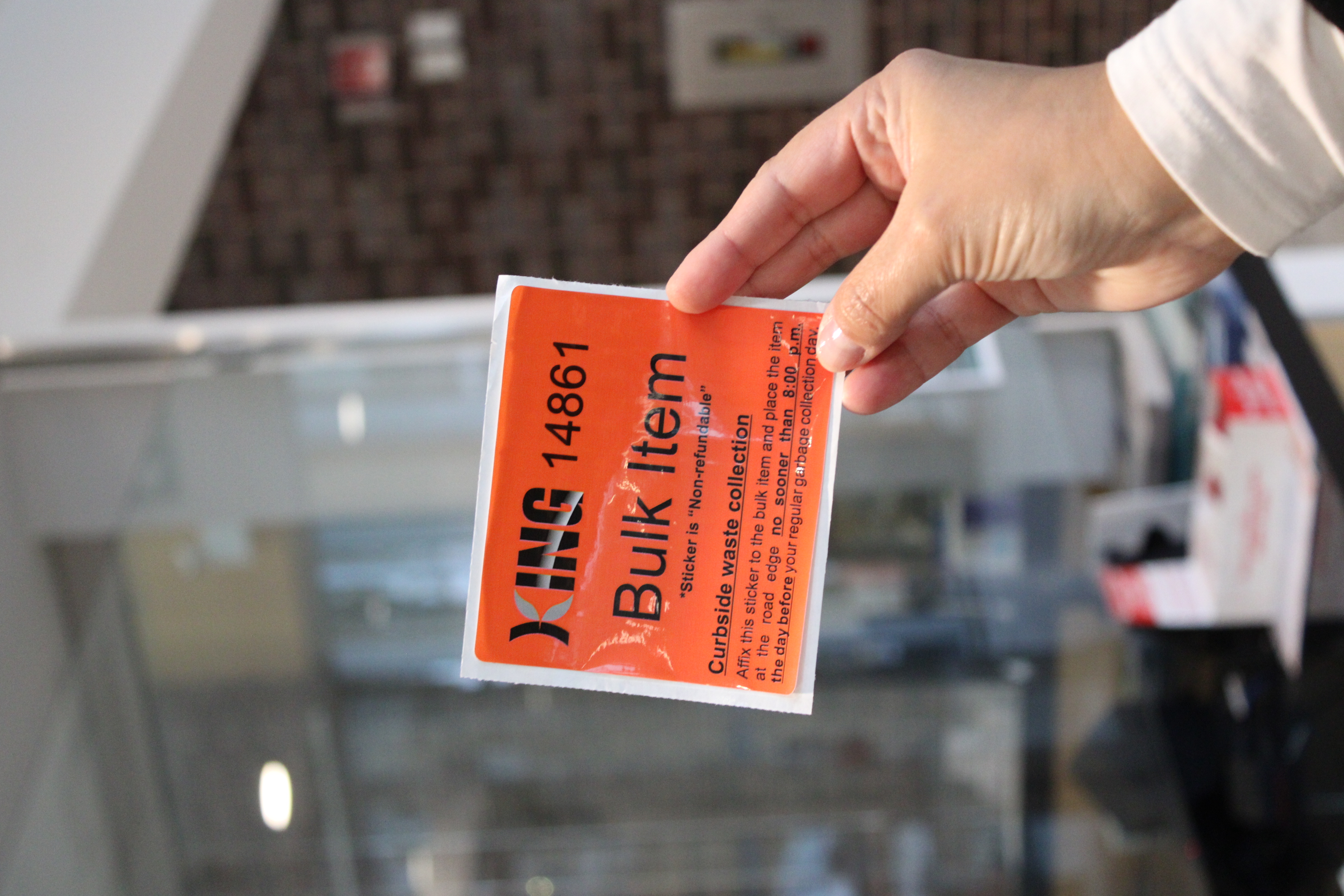 Hand holding orange bulk item sticker