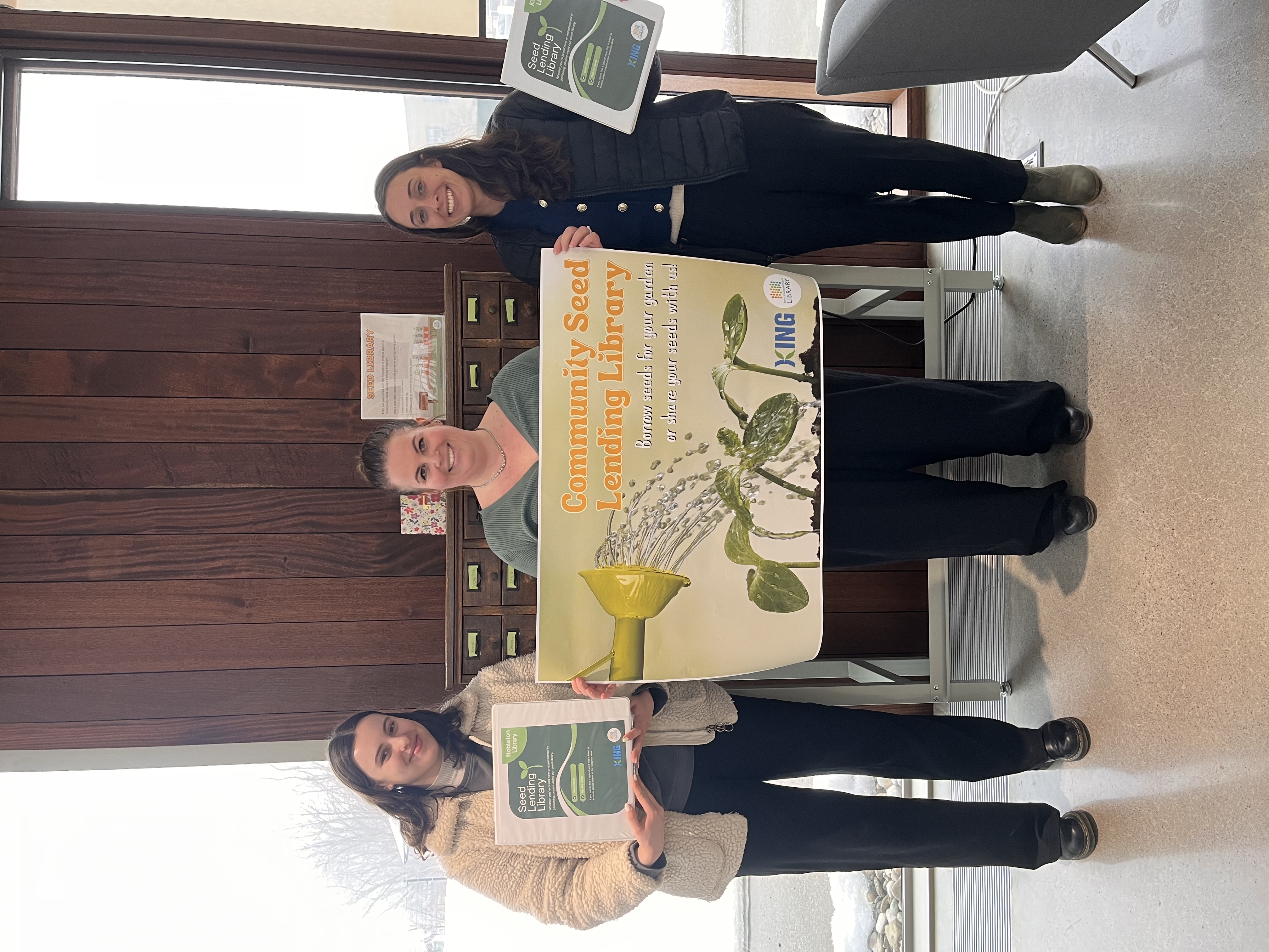Staff holding a King Township Seed Lending Library poster