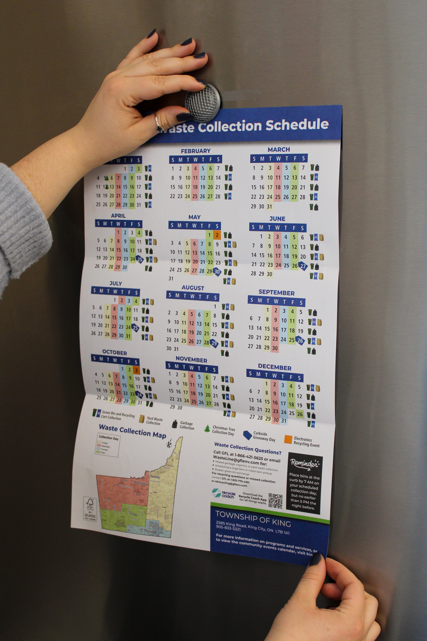 Image of hand holding magnet placing Waste Calendar Schedule onto a fridge