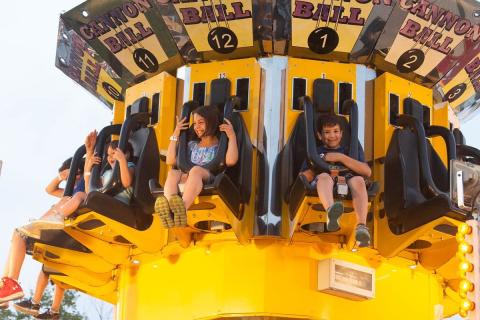 children on a yellow ride at the fair