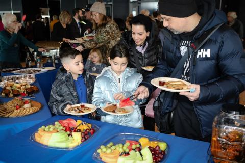 Adult serving child breakfast food