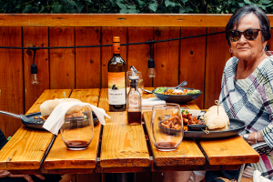 three women sitting at a patio table enjoying dinner