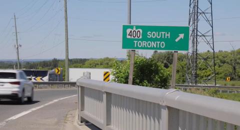 sign of 400 south toronto with some vehicles