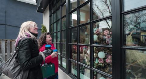 Two women outside of a retail store window shopping